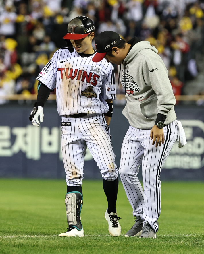 14일 서울 잠실야구장에서 열린 2026 신한 SOL KBO 포스트시즌 와일드카드 결정전 1차전 두산 베어스와 LG 트윈스의 경기. 8회말 1사 1, 3루 LG 신민재가 스퀴즈 번트에 성공한 후 통증을 호소하며 교체되고 있다. 연합뉴스 