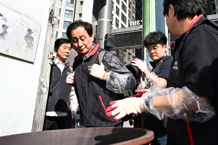 연탄 나눔 봉사를 중인 강무길 부산시의회 의장(중간)과 김재운 운영위원장(왼쪽). 부산시의회 제공