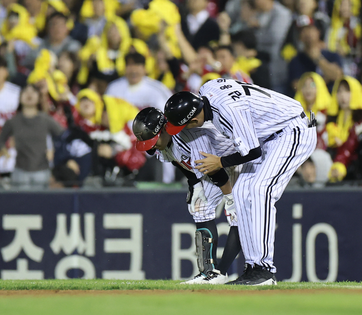 지난 14일 서울 잠실야구장에서 열린 LG 트윈스와 두산 베어스의 2026 신한 SOL KBO 포스트시즌 와일드카드 결정전 1차전. 8회말 1사 1,3루 LG 신민재가 번트를 쳐내고 1루를 밟은 뒤 김용의 코치에게 햄스트링 통증을 호소하고 있다. 연합뉴스