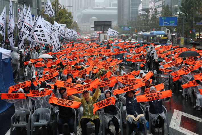 18일 서울 숭례문 앞에서 열린 '전국택배노동자대회'에서 참석자들이 수입감소 없는 주5일 쟁취 등을 촉구하며 손피켓을 들어보이고 있다. 연합뉴스