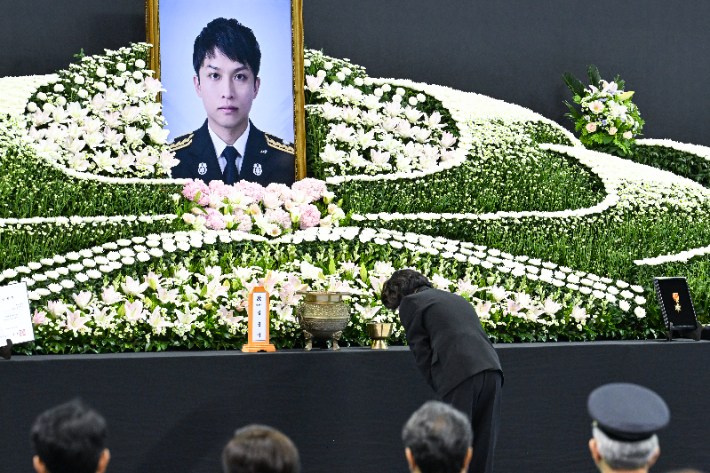추미애 경기도지사가 19일 부천실내체육관에서 열린 '고(故) 김진석 소방위 영결식'에서 헌화 뒤 묵념하고 있다. 연합뉴스
