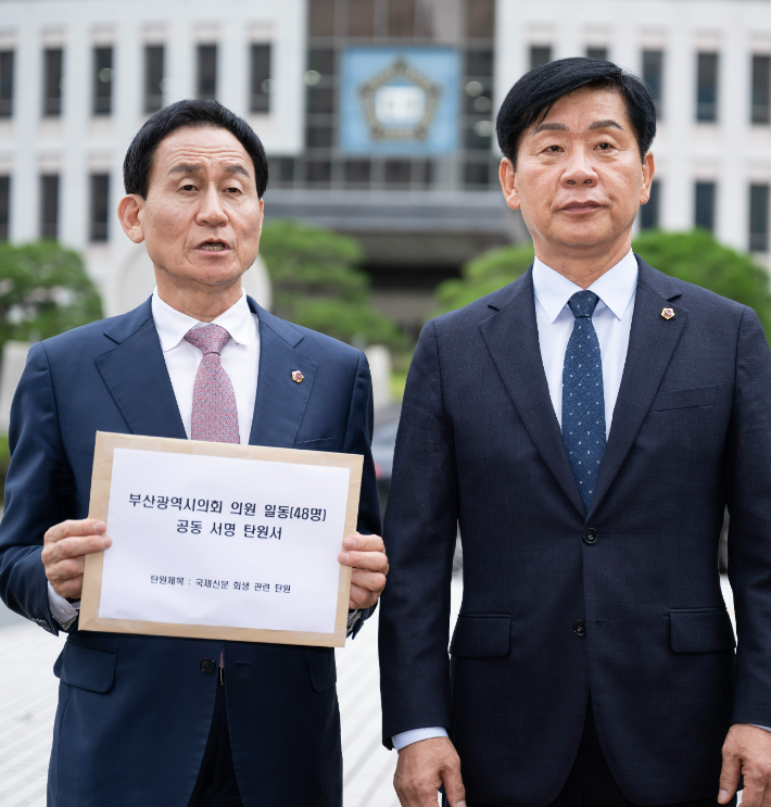 강무길(왼쪽) 부산시의회 의장과 김재운 운영위원장이 국제신문 기업회생 인가를 촉구하는 탄원서를 19일 부산회생법원에 제출하고 있다.  탄원서에는 시의원 48명 전원이 서명했다. 국제신문 비상대책위원회 제공