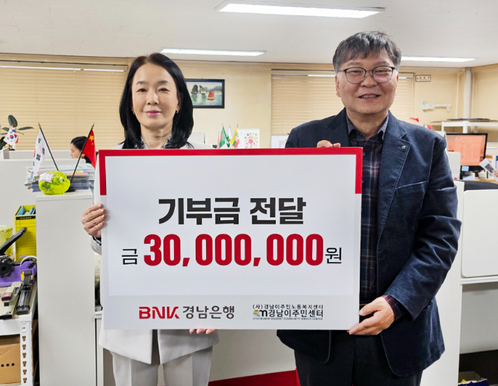 BNK경남은행 최명희 그룹장(사진 왼쪽)이 (사)경남이주민노동복지센터 이철승 대표에게 기부금 3천만원을 전달하고 있다. BNK경남은행 제공