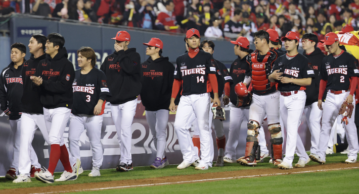 KIA 타이거즈 선수들이 20일 서울 잠실야구장에서 열린 LG 트윈스와의 KBO 프로야구 포스트시즌 준플레이오프 3차전에서 13-1로 승리하며 플레이오프 진출을 확정한 뒤 더그아웃으로 향하고 있다. 연합뉴스 