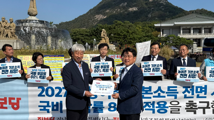 박형대 의원(왼쪽)이 21일 청와대 앞에서 이영수 농림축산비서관에게 농어촌기본소득 전면 시행을 촉구하는 의견서를 전달하고 있다. 전남광주통합특별시의회 제공