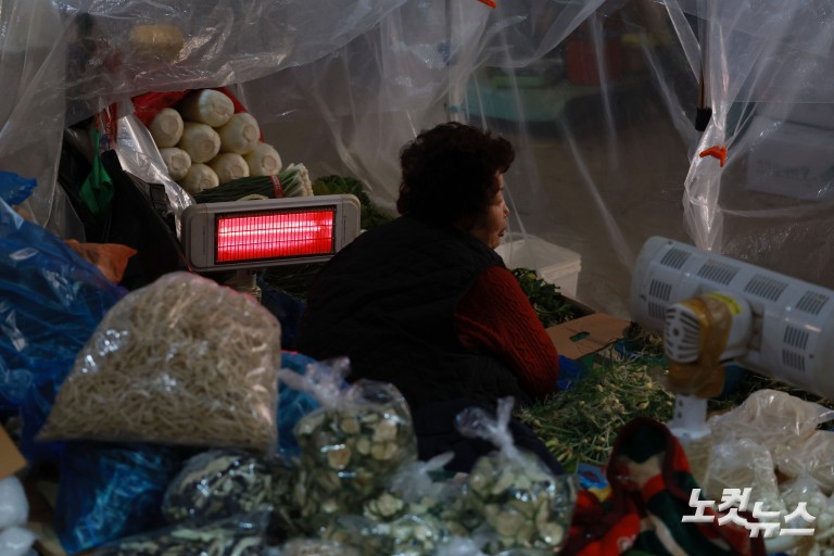 난로 쬐며 추위 녹이는 시장 상인들