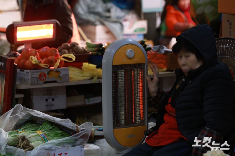 난로 쬐며 추위 녹이는 시장 상인들