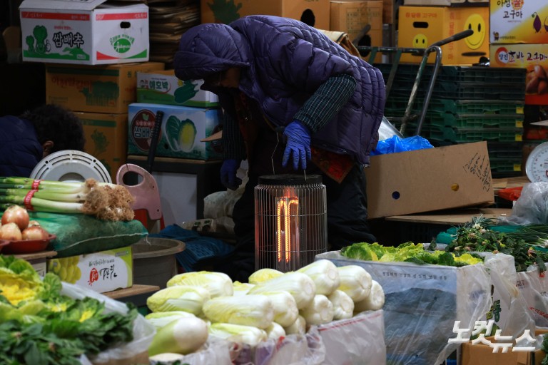 난로 쬐며 추위 녹이는 시장 상인들