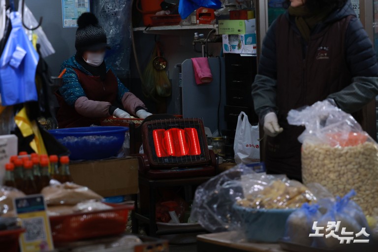난로 쬐며 추위 녹이는 시장 상인들