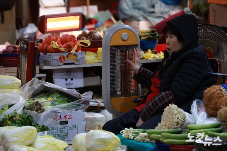 난로 쬐며 추위 녹이는 시장 상인들